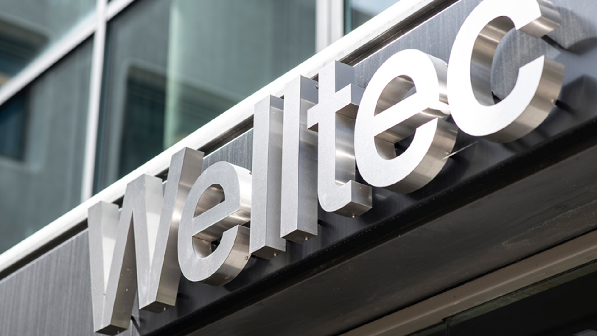 Close-up of Welltec's building signage with the company logo displayed on a modern glass structure.