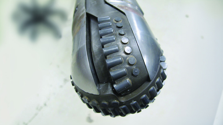 Close-up of Well Miller expandable bit showing cutting elements and rugged design after testing.