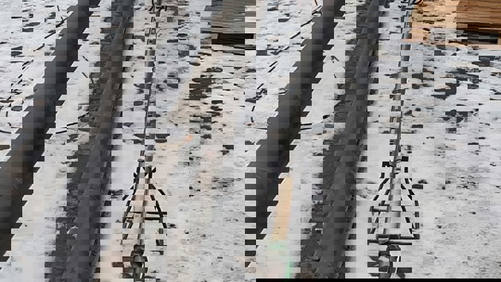 Perforation system tool staged on snowy ground for its first conveyance during a well intervention, alongside other tubular equipment.